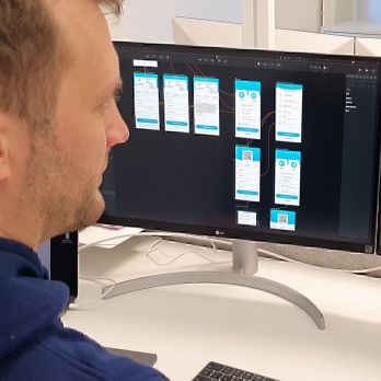 Zwei Entwickler schauen auf Bildschirm am Computer mit UI Interface