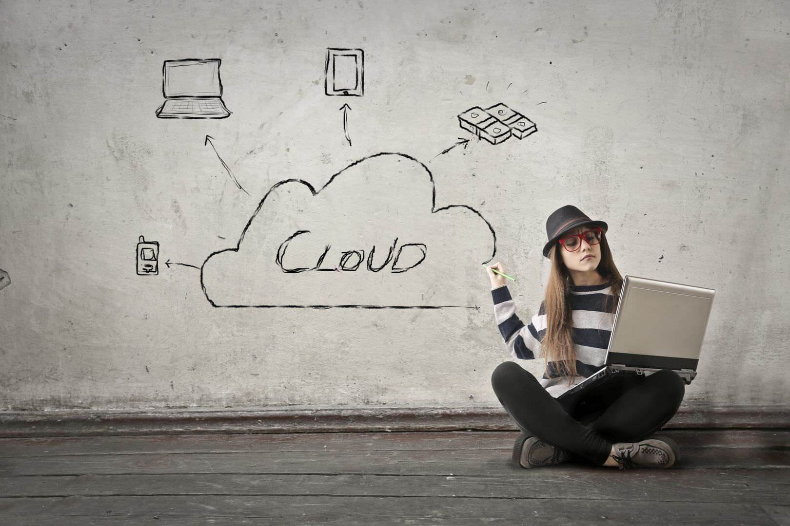 SAP Marketing Cloud Frau mit Notebook im Schneidersitz zeigt auf Wand wo "Cloud" geschrieben steht